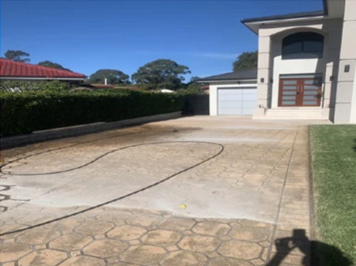 Before - A stained driveway looks out of place in front of a modern home.