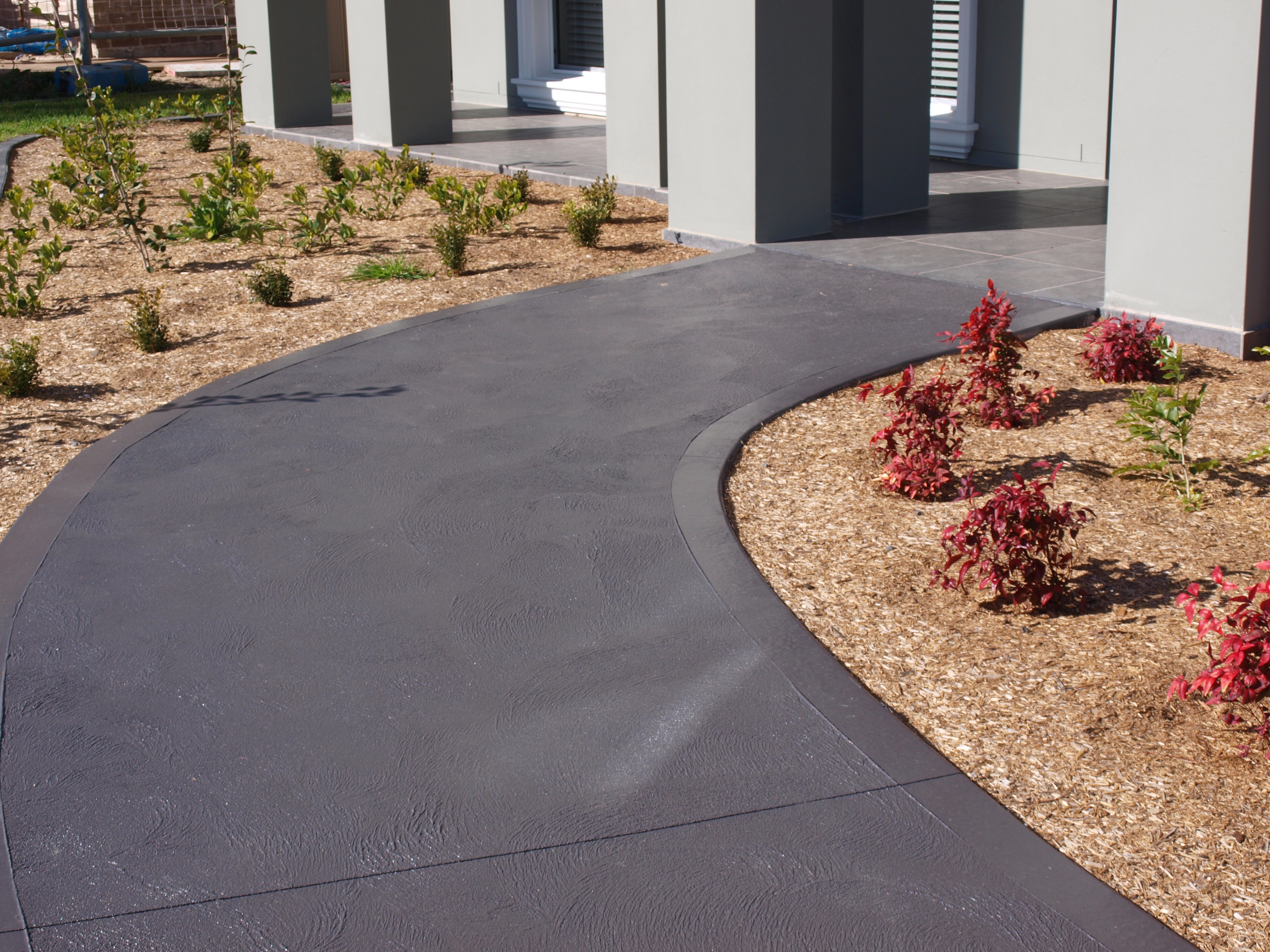 Dulux Avista Colour Hardener in Gunmetal has been hand cast over freshly poured concrete. The applicator has used a trowel finish to add texture.