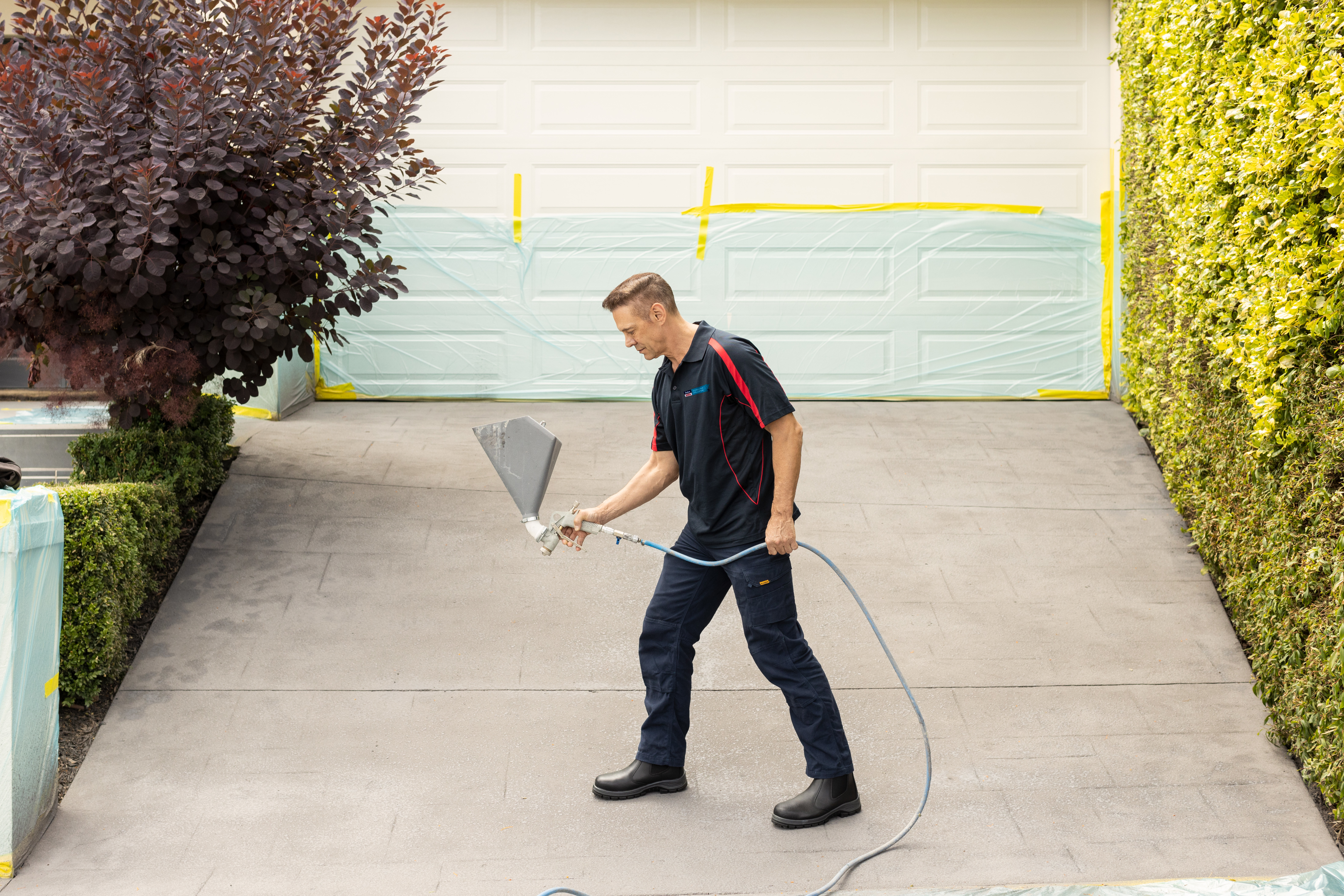 During concrete resurfacing, texture coats are applied with a hopper gun.